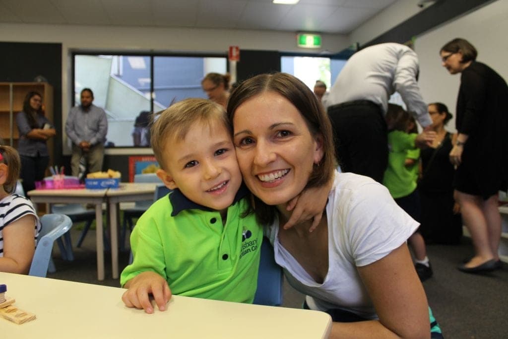 mother and son in school, boy wearing uniform and both smiling