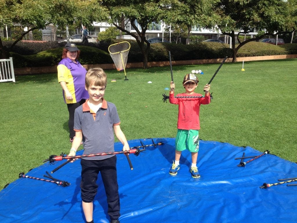 Kids enjoying outdoor circus-style play activities on the lawn at Roma Street Parkland Brisbane