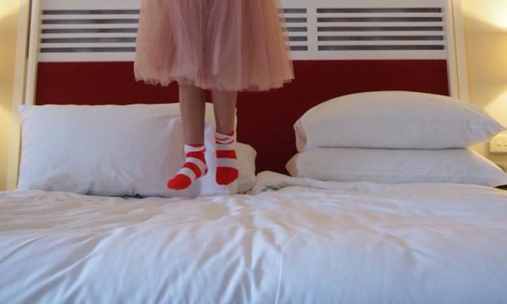 Surfers Paradise Marriott Resort & Spa - little girl in stripey socks jumping on big fluffy bed