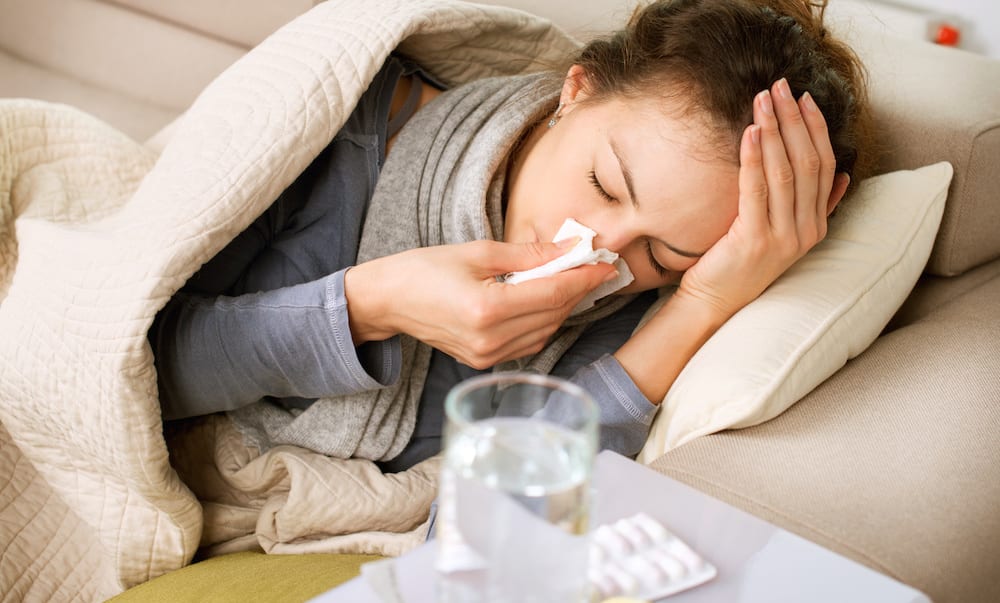 Sick Woman. Flu. Woman Caught Cold. Sneezing into Tissue