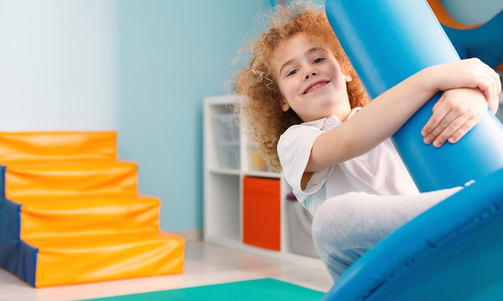 Occupational Therapist Gold Coast Happy boy using blue disc swing for therapy