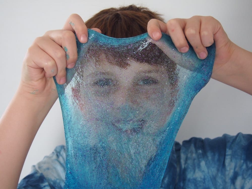 Glitter Slime stretched in front of face