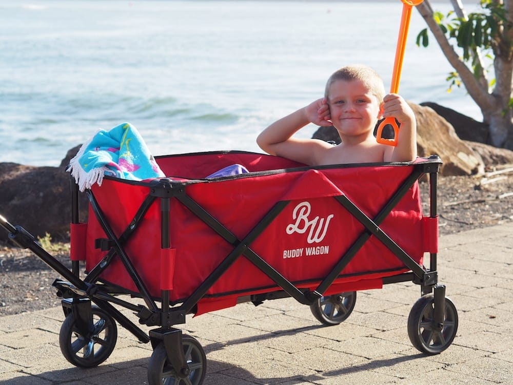 Boy being dragged in red Buddy Wagon