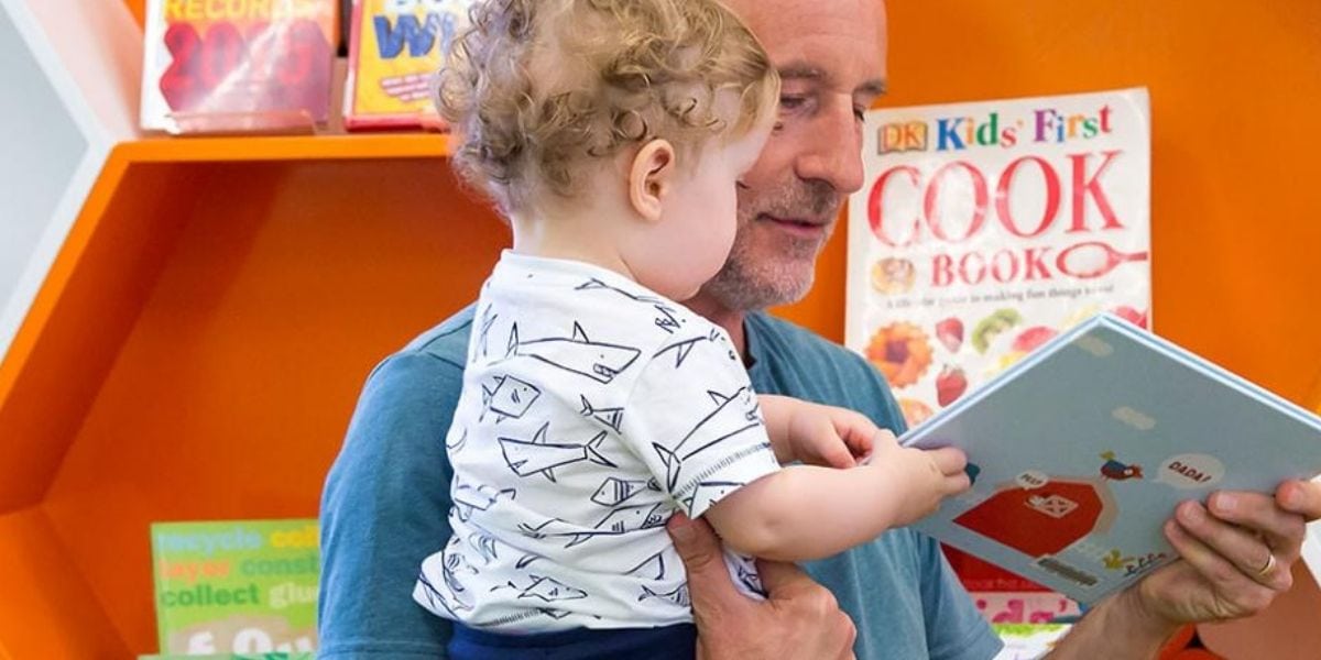 A toddler with a cookbook