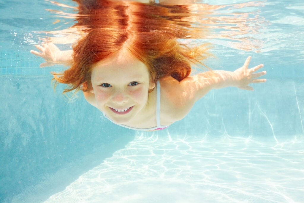 girl confidently swimming underwater