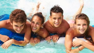 Group Of Teenage Friends Having Fun In Schoolies Accommodation Swimming Pool