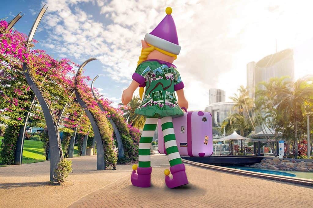 Giant inflatable Christmas elf arriving at South Bank Brisbane with suitcase under the bougainvillea arbour for Christmas 2025 celebrations.