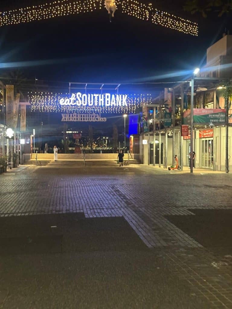 Eat South Bank sign and festive lights glowing at night along Little Stanley Street in South Bank Brisbane.