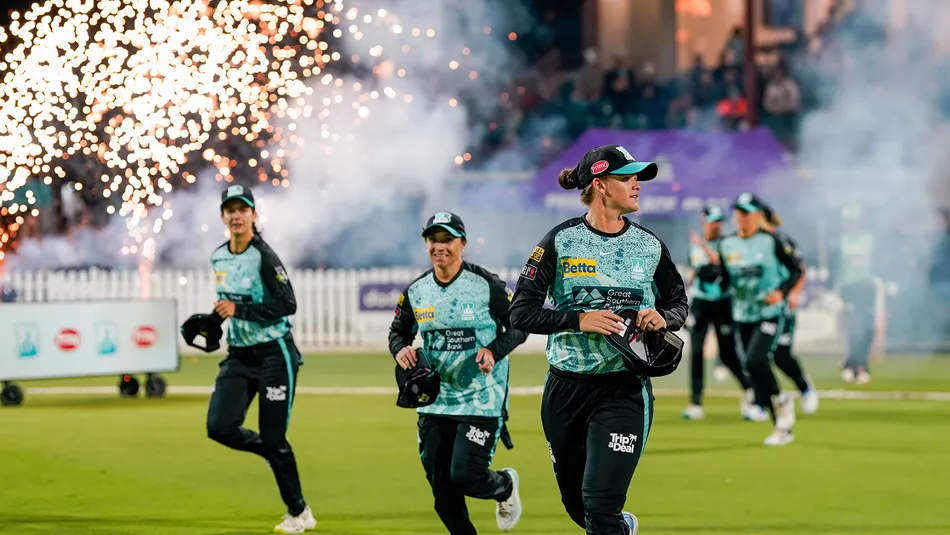 WBBL Brisbane Heat team running onto the field amid fireqorks