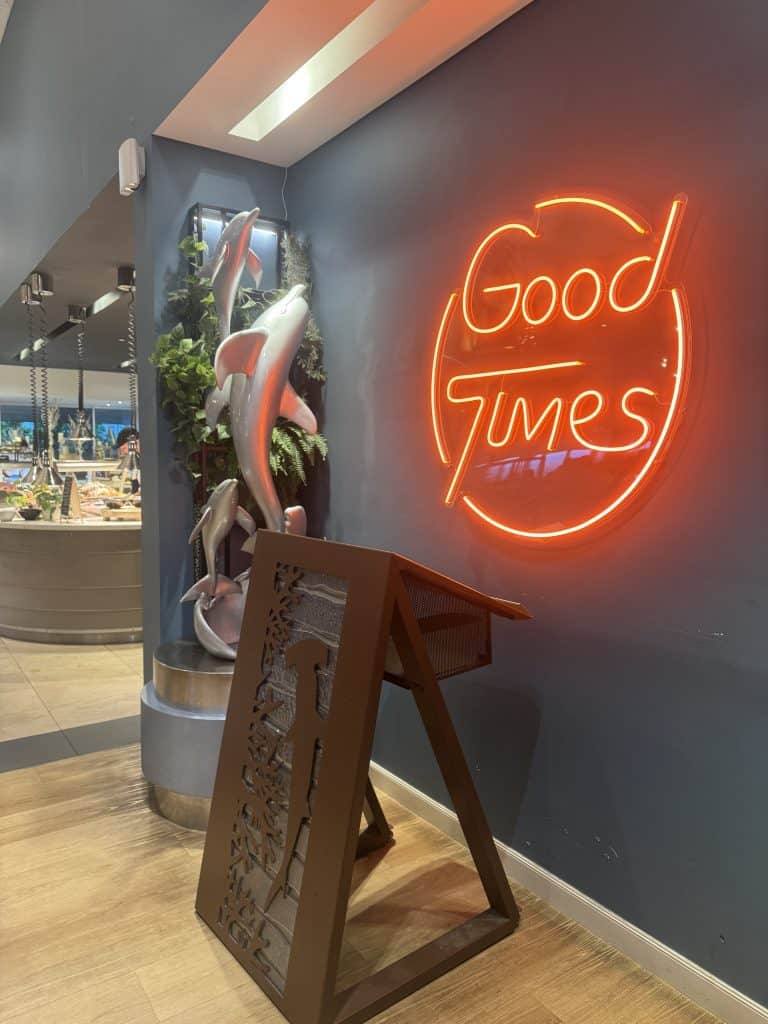 The welcoming โGood Timesโ neon sign inside Shoreline Restaurant at Sea World, setting the tone for a relaxed family dining experience.