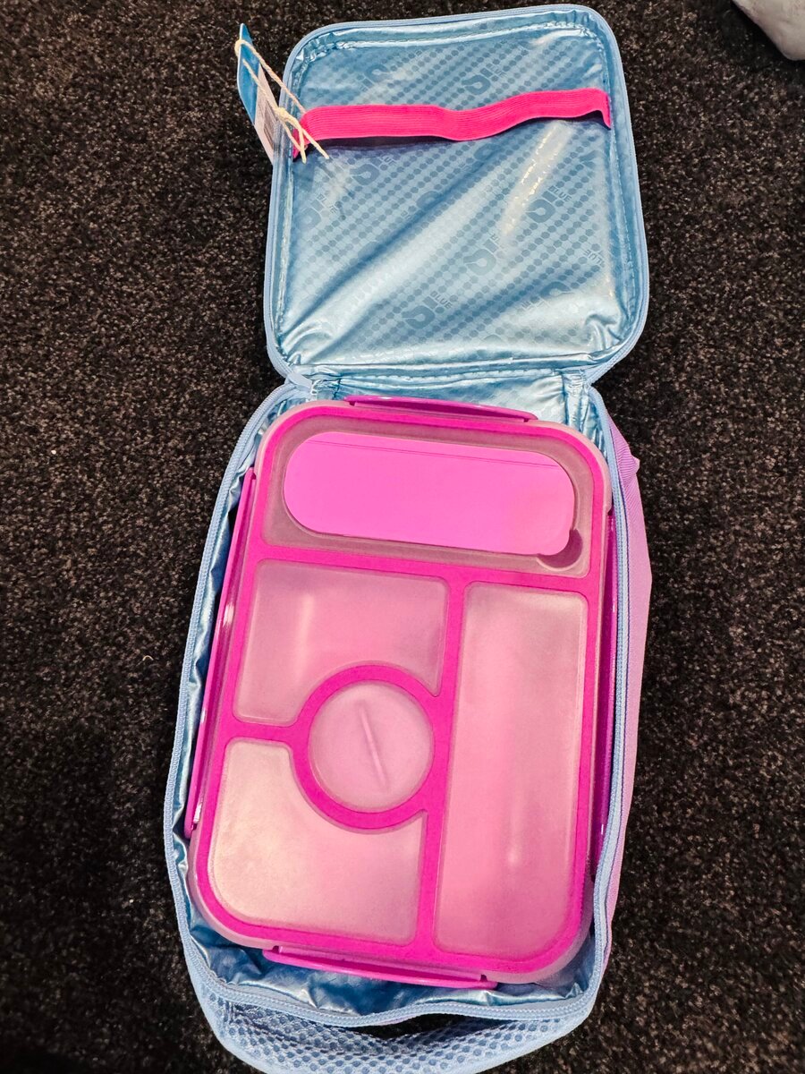 Purple kids’ bento lunch box neatly fitted inside a blue insulated school lunch bag.