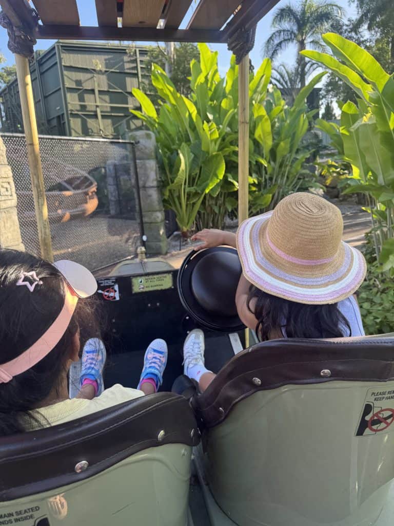 Children enjoying the driving ride at Dreamworld on the Gold Coast, steering through river surroundings.